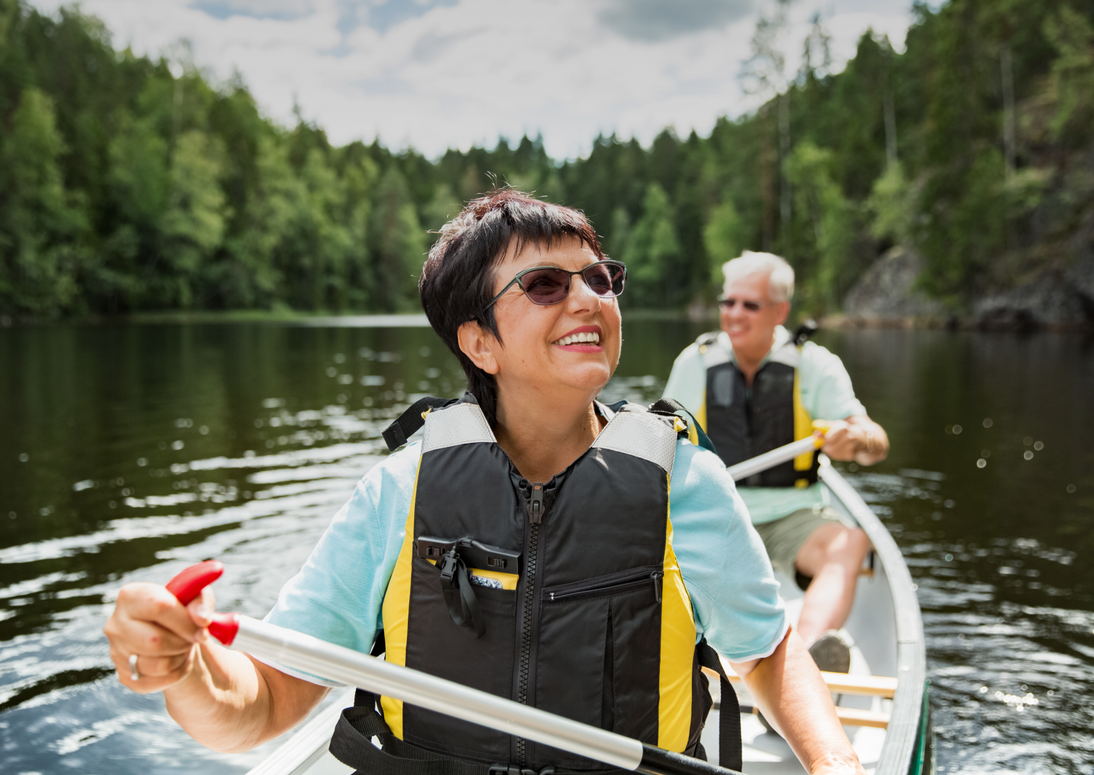 Smiling woman with a man in a boat going along a river